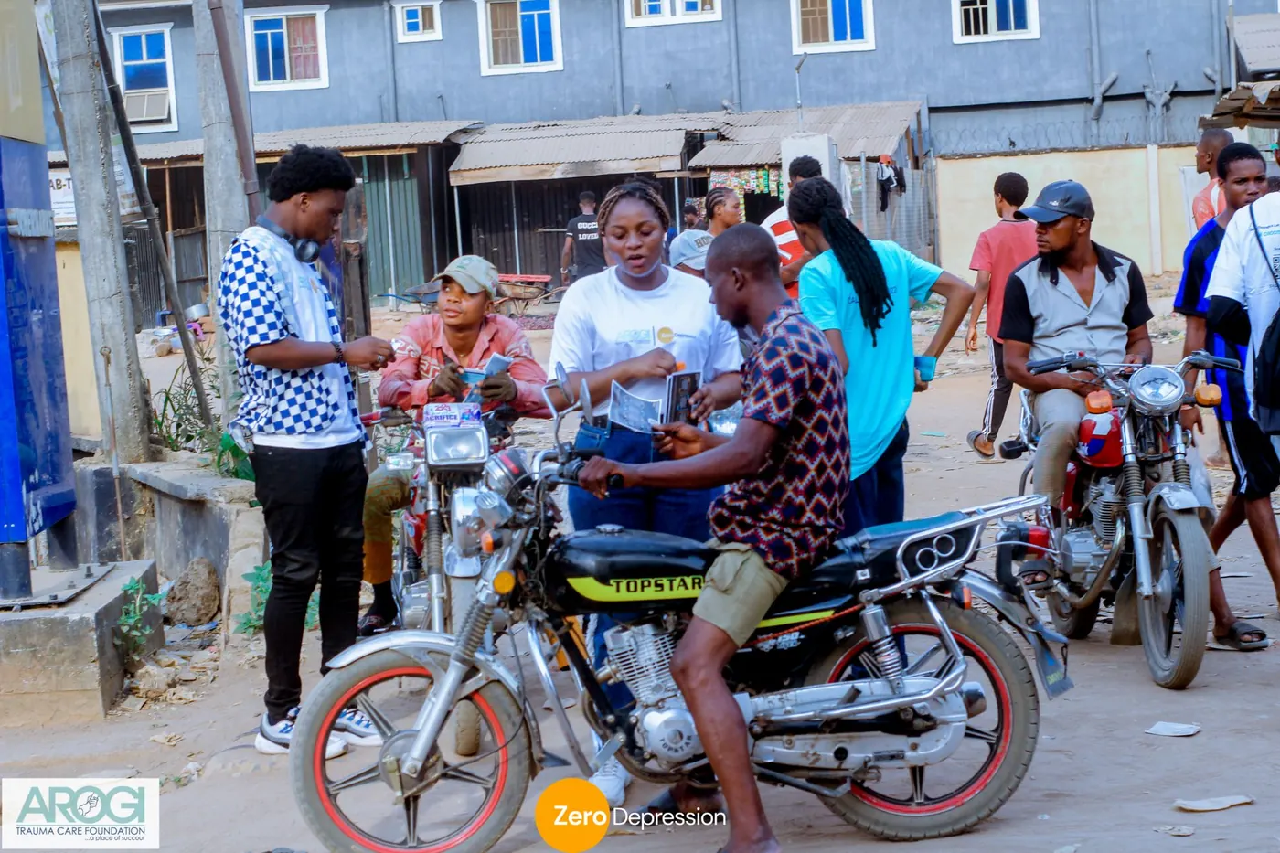 A volunteer sharing a flyer with a group of motorbike riders at a roadside