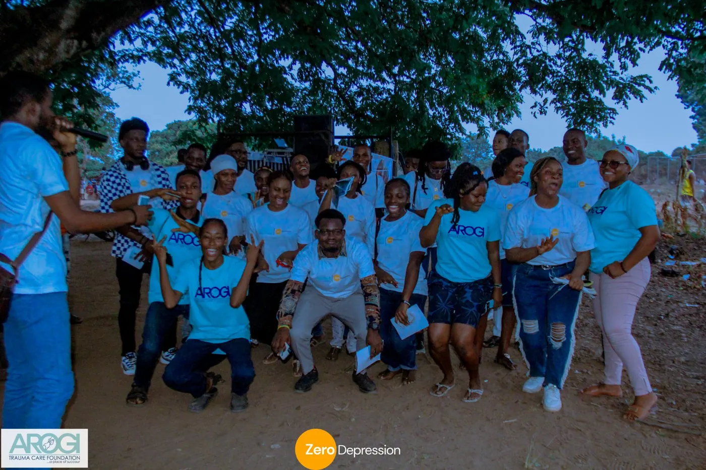 Volunteers in white and blue t-shirts cheering together after the walk as dusk falls